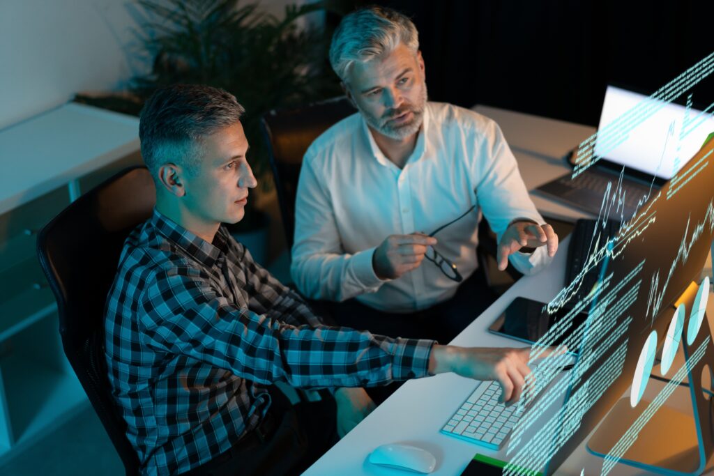 Two,Businessmen,Analyzing,Data,On,Computer.,Colleagues,Discussing,Performance,Metrics