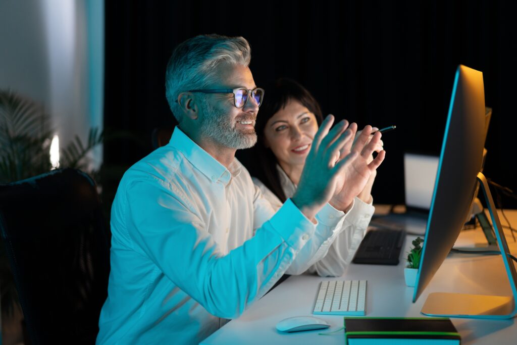 Two,Colleagues,Collaborate,On,Computer,Project,,Smiling,And,Engaged,In